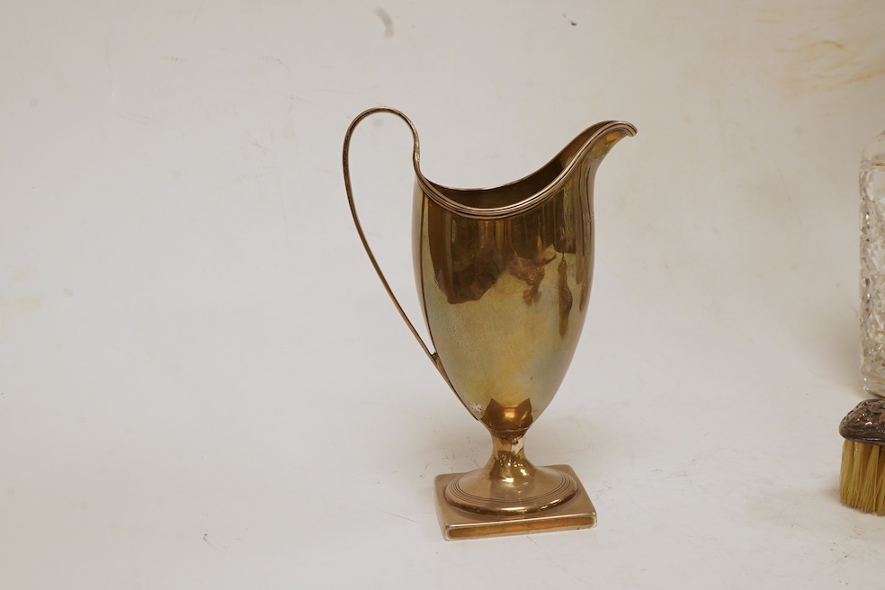 A George III silver helmet shaped cream jug, London, 1796, 14.7cm, together with two silver topped glass scent bottles, one Victorian, a pair of late Victorian silver dwarf candlesticks, London, 1895, a silver mounted ha